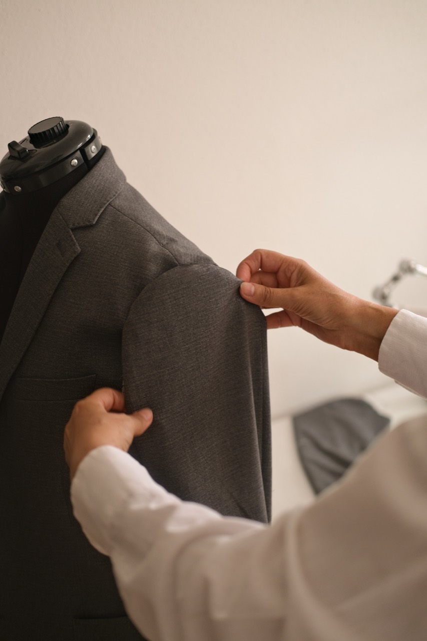 Alla Shevchuk prüft die Passform eines grauen Jacketts